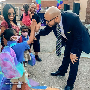 Dr. Alex Marrero high-fiving  a student